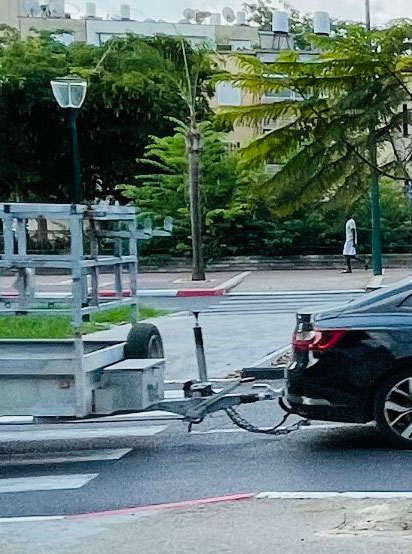 Car pulling a trailer on a roundabout in a city